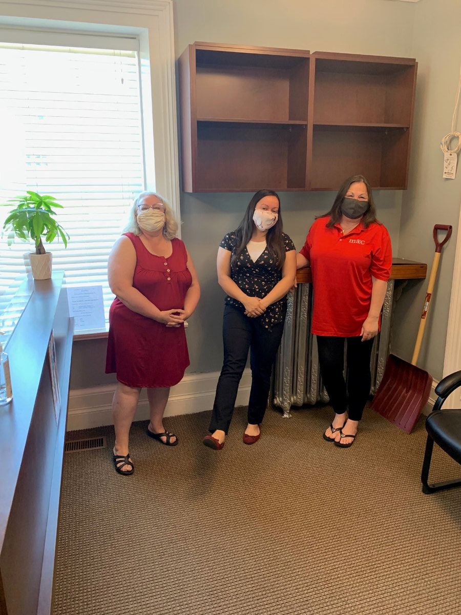 Three of the GGFI team standing in front of a gray wall.